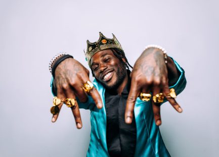 portrait of an hip hop music musician. Cinematic image of a man wearing party clothes and jewels