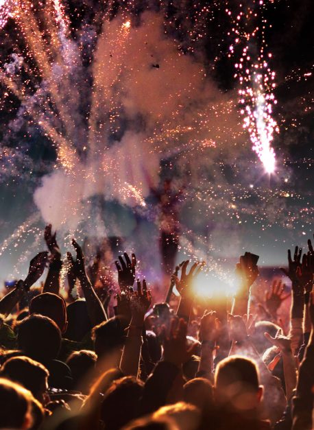 crowd with raised hands at concert festival banner