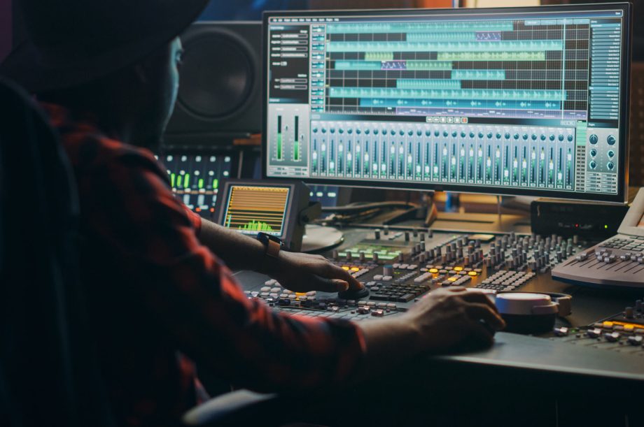 Music Creator, Musician, Artist Works in the Music Record Studio, Uses Surface Control Desk Equalizer Mixer. Buttons, Faders, Sliders to Broadcast, Record, Play Hit Song. Close-up Shot